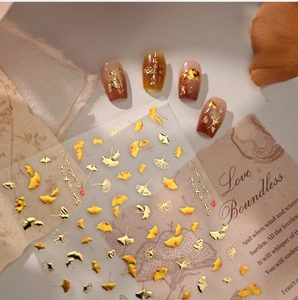 Close-up of gold and yellow ginkgo leaf nail stickers with metallic foil details