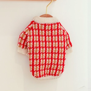Detail of red and white checkered knit pet sweater with ribbed collar on wooden hanger
