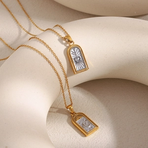 Détail de colliers tarot plaqués or 18 carats avec pendentifs rectangulaires cœur et lune