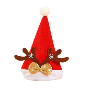 Red velvet Christmas hat with brown reindeer antlers and gold bow on white background