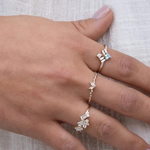 Close-up of luxury 18K gold rings with baguette diamonds and a square blue gemstone