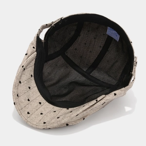 Beige herringbone cotton newsboy cap with black heart pattern and 100% cotton inner label