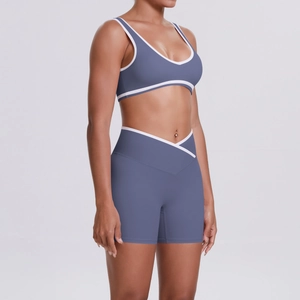 Detail of high-waisted crossover yoga shorts and sports bra in misty blue with white trim
