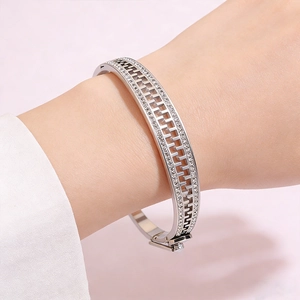 Detail of silver stainless steel zipper bangle with pavé stones and hollow geometry