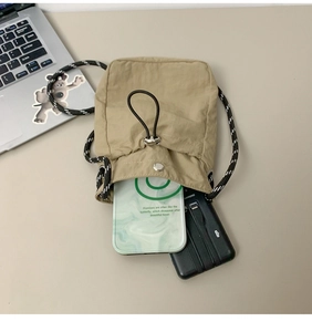 Top view of beige drawstring bag showing internal capacity with laptop background