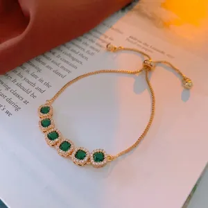 Elegant adjustable gold bracelet with square emerald gemstones and white zircon halo details
