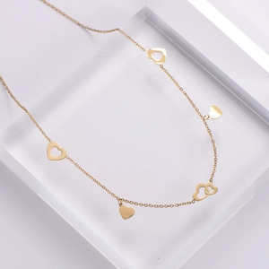 Elegant gold titanium steel necklace featuring multiple heart pendants on a display stand