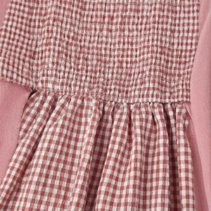 Red gingham sleeveless midi dress featuring smocked chest detail and pleated skirt style