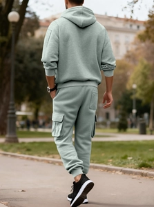 Outdoor back view of men's mint green hoodie and cargo jogger pants street style set