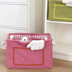 Detail of plush monster storage baskets in pink and green with soft sherpa texture