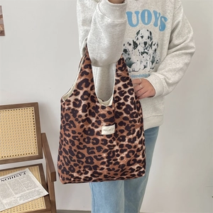 Detail of leopard print canvas tote bag with woven studio brand label and large capacity