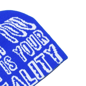 Macro detail of royal blue knit beanie featuring white IS YOUR REALITY jacquard text