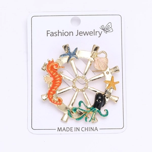 Detail of nautical brooch featuring enamel seahorse and octopus on golden ship wheel