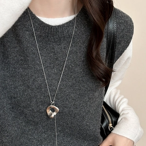 Minimalist silver irregular hollow pendant necklace shown on a grey sweater
