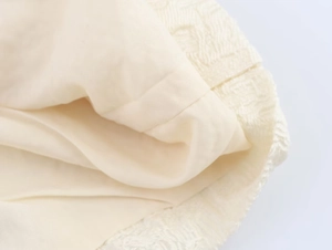 Vue macro détaillée de la doublure en satin crème et de la dentelle sur l'ensemble