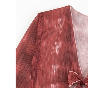 Détail du haut de bikini en mesh marron rouge avec plis verticaux et décoration de nœud papillon