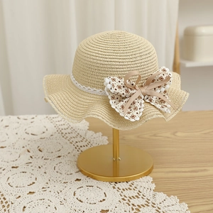 Détail du chapeau de paille pour filles avec ruban en dentelle et nœud floral à pois