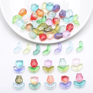 Macro shot of gradient glass tulip and leaf beads for DIY handmade jewelry crafts