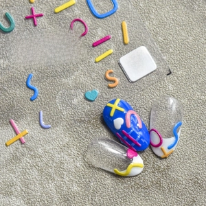Detail of 5D embossed nail stickers featuring colorful lines, stars and heart patterns