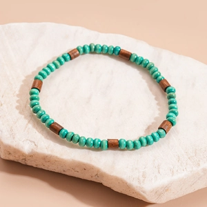 Detailed close-up of bohemian beaded bracelet set with turquoise beads and brown wood