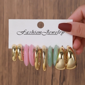Set of five pairs of colorful acrylic and gold C-shaped hoop earrings on display card
