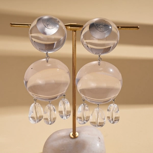 Boucles d'oreilles pendantes en résine transparente avec crochets dorés sur un support