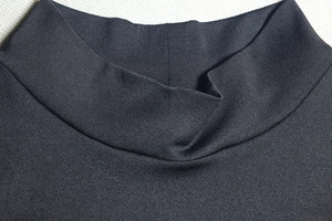 Close-up of the black high-neck knit collar showing fine ribbed fabric texture