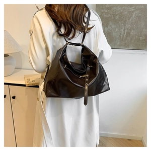 Deep chocolate brown large PU leather tote bag shown in a cozy indoor minimalist setting