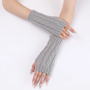 Close-up of grey cable knit fingerless gloves showing texture and forearm length