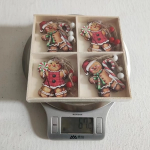 Detail of wooden gingerbread man Christmas ornaments in a grid box on a scale