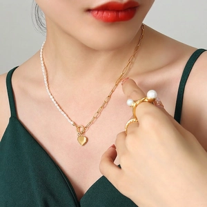 Elegant gold chain and pearl necklace with heart pendant and matching pearl ring