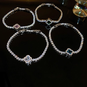 Macro shot of clover-shaped zirconia bracelets in purple, green, white, and blue finishes