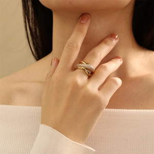 Close-up of elegant 18K gold plated X-shaped ring with pavé cubic zirconia on hand