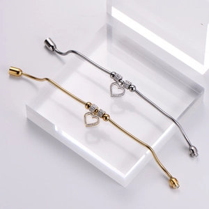 Detail of silver and gold snake chain bracelets with sparkling heart pendants