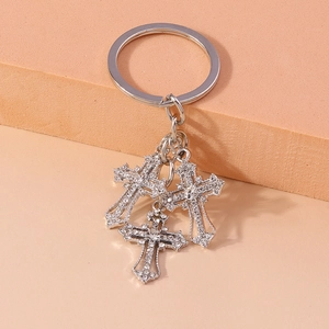 Close-up of silver-tone keychain featuring three pendants with sparkling rhinestones