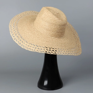 Detail of wide brim raffia sun hat with intricate hollow woven patterns for summer