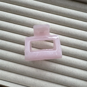 Macro shot of pink marble texture on a rectangular hollow hair claw clip with glossy finish