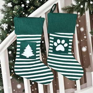 Chaussettes de Noël tricotées avec sapin et empreintes suspendues sur escalier blanc