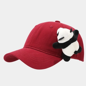 Vue détaillée de la casquette rouge en coton avec une peluche de panda 3D sur le côté