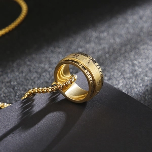 Macro shot of rotatable golden mantra ring pendant with matching metal pearl chain