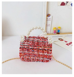 Detail of tweed mini handbag with elegant pearl handle and golden chain strap