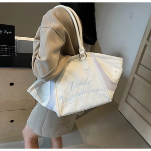 Detailed embroidery on white bowling bag with mesh stitching and casual shoulder strap