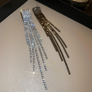 Detail shot of luxury long tassel earrings with sparkling rhinestones in silver and gunblack