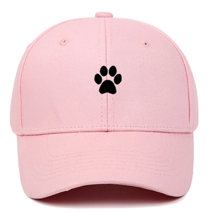 Detailed view of pink cotton baseball cap featuring black paw embroidery and curved brim