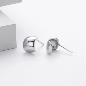 Primer plano de pendientes de plata S925 pulida con diseño minimalista en forma de C