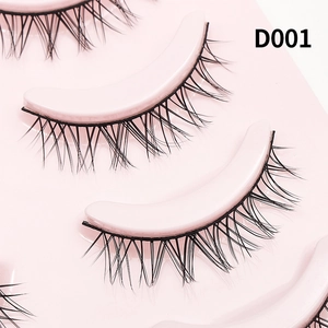 Macro shot of D001 natural black false eyelashes on a pink tray with detailed root fibers