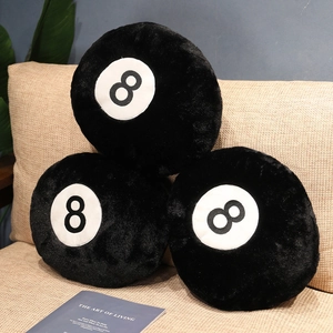 Detailed plush texture of black no. 8 billiard ball pillows stacked on a sofa
