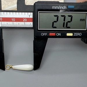 Primer plano de un colgante de nácar blanco en forma de gota de 27,2 mm con cierre dorado