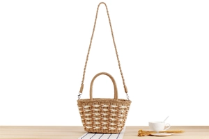 Detail of hand-woven straw tote with wavy pattern texture and detachable shoulder strap