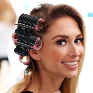 Salon hair roller set with pink rollers and black clips shown on a blonde model